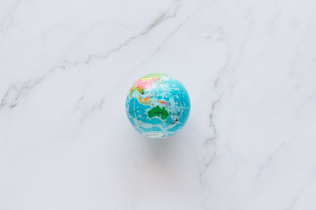 Home A small, colorful globe rests on a marble surface, symbolizing global exploration and travel planning.