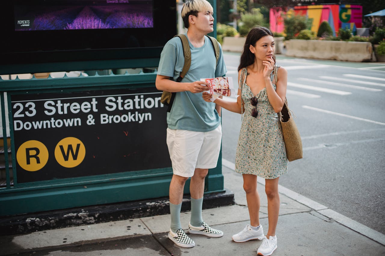 Services Full body of diverse couple standing with map while trying to find direction in city center during trip